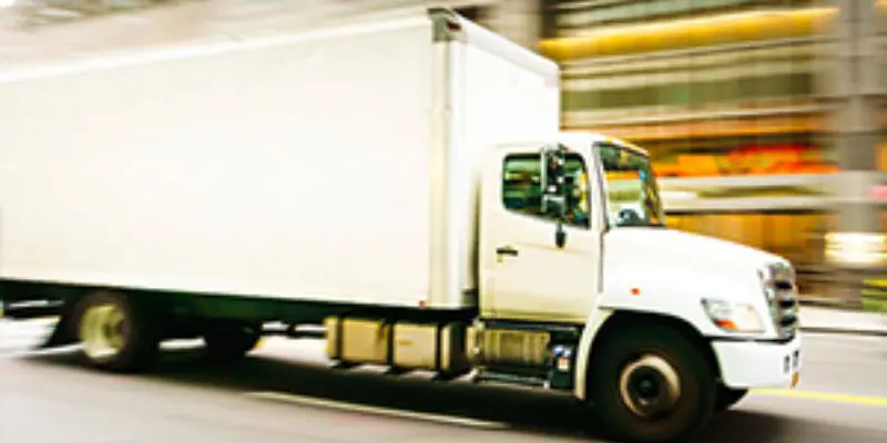 A white truck driving down the street.